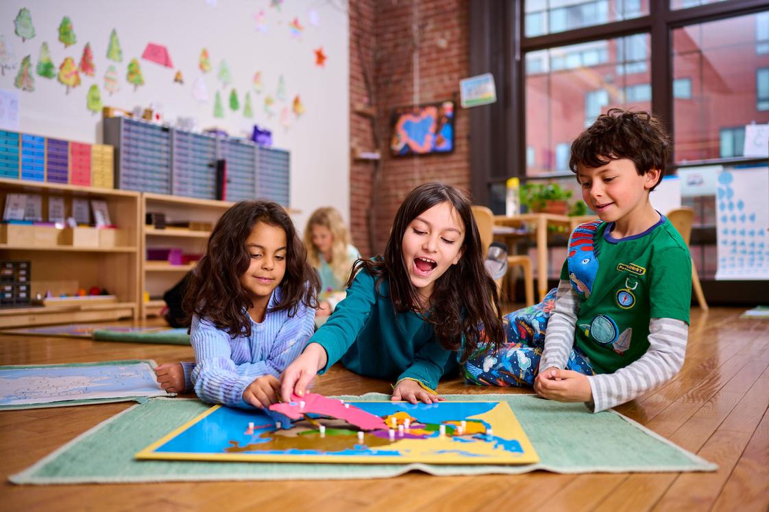 Kingsley Montessori School Photo - Elementary students exploring a geography work. A key component of the Kingsley mission is raising empathetic global citizens-students who care deeply for the world and work together to improve it.