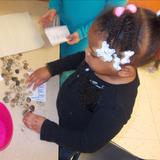 Whitcomb KinderCare Photo - Our Juniour Kindergartners stepped back into time during our Dinosaur unit! Here, a child enjoys writing her name in stones in our prehistoric writing center!